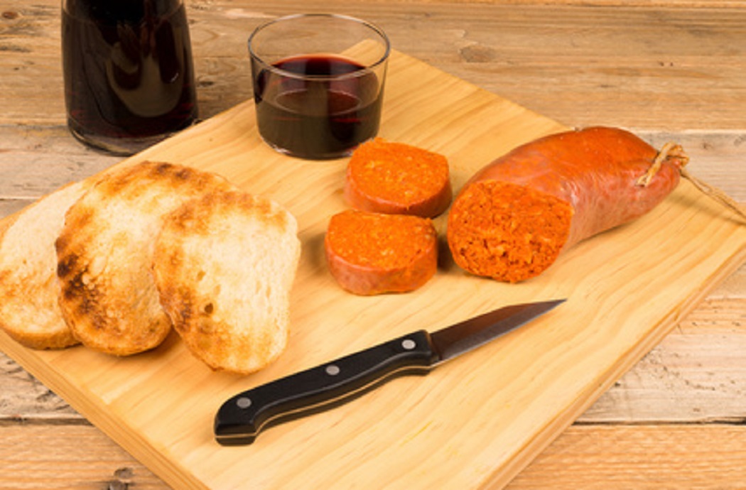 Sobrasada artesana untada sobre pan con una copa de vino